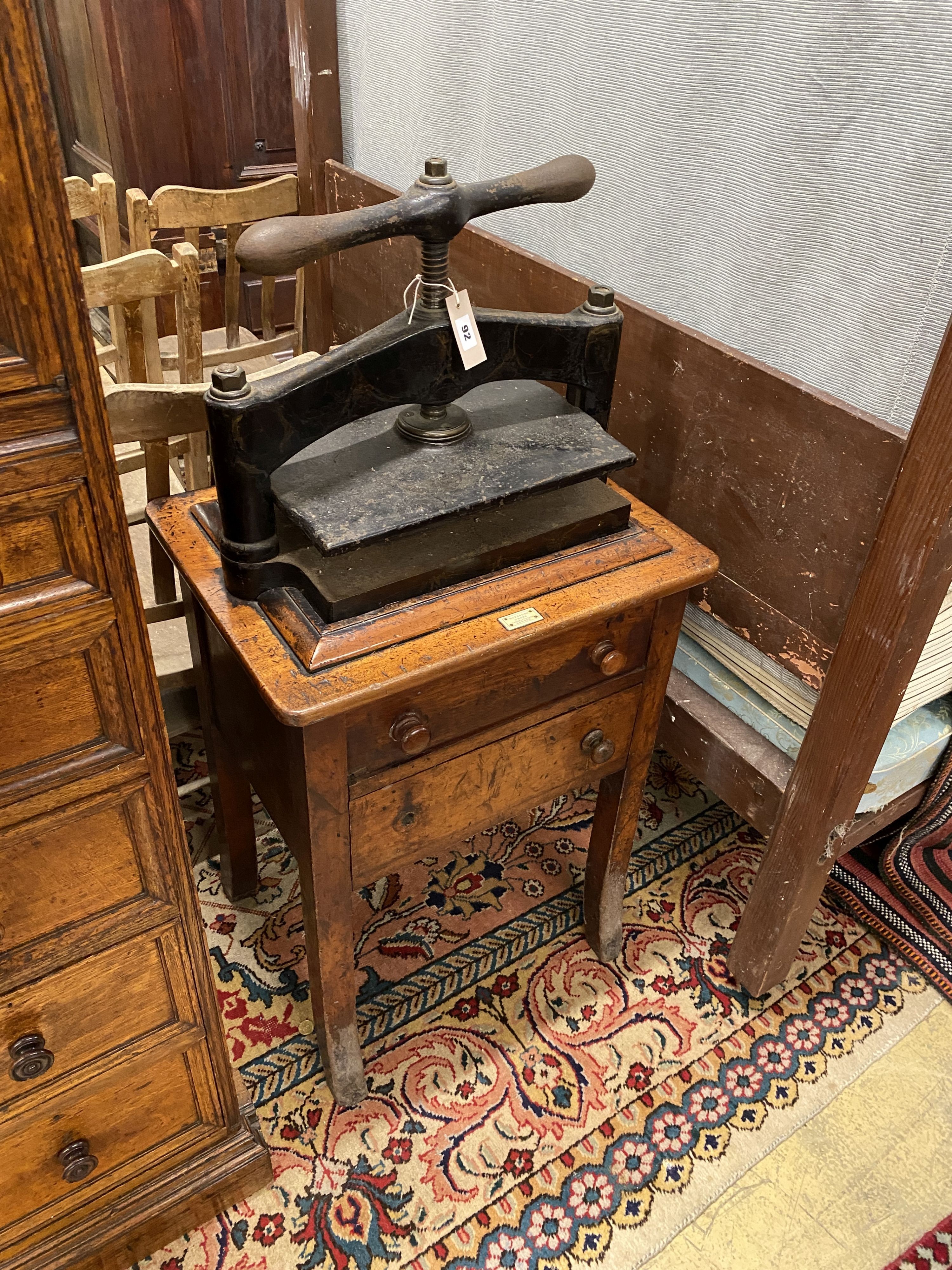 A Victorian cast iron book press on mahogany stand, marked Waterlow & Son, London, width 55cm, depth 43cm, height 118cm